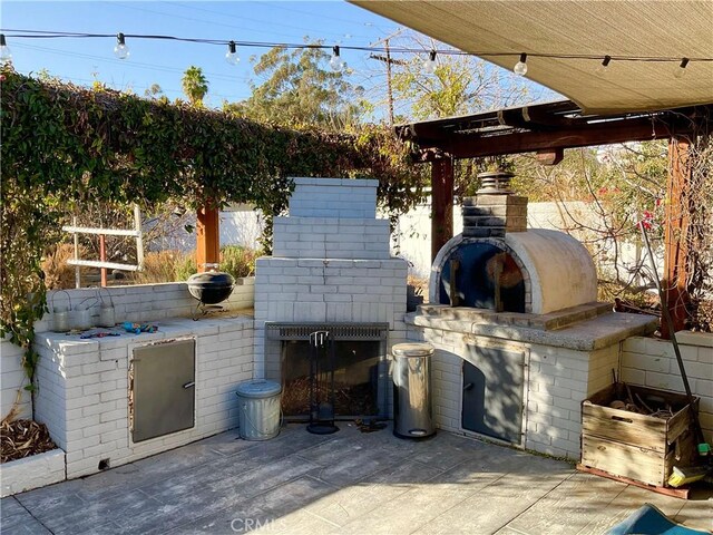 view of patio / terrace with an outdoor brick fireplace and exterior kitchen