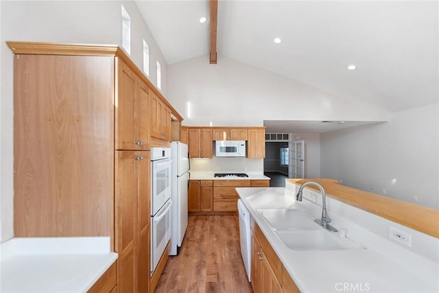 kitchen with sink, white appliances, high vaulted ceiling, light hardwood / wood-style floors, and beamed ceiling