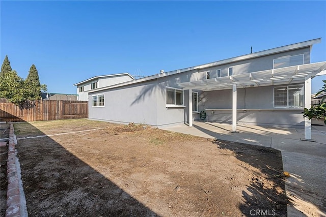 back of house with a pergola, a patio area, and a lawn