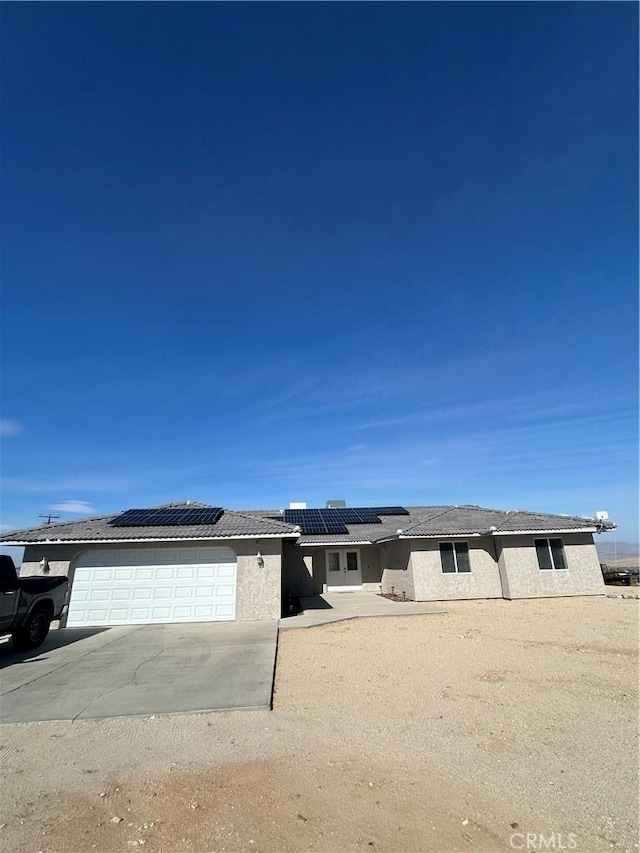 view of front of house with a garage and solar panels