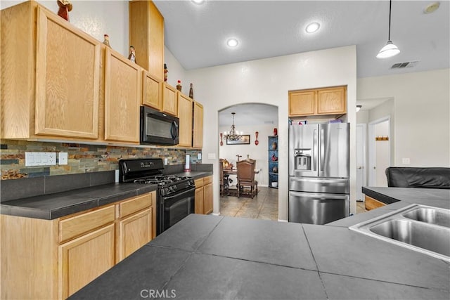 kitchen featuring tile countertops, light brown cabinetry, and black appliances