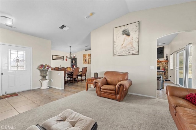 living room with a notable chandelier, vaulted ceiling, and light colored carpet