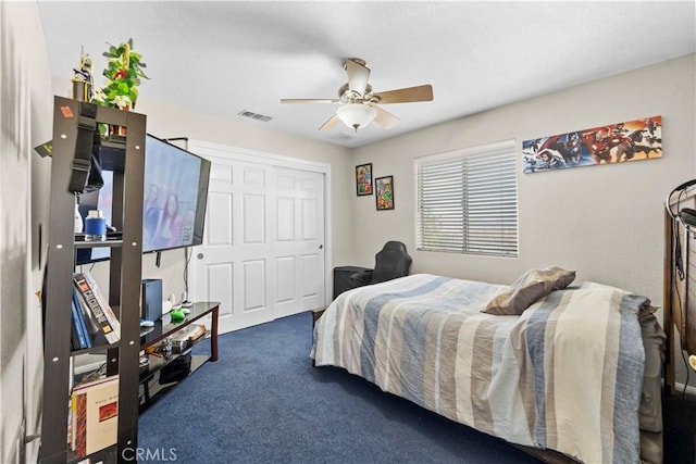 carpeted bedroom featuring ceiling fan and a closet