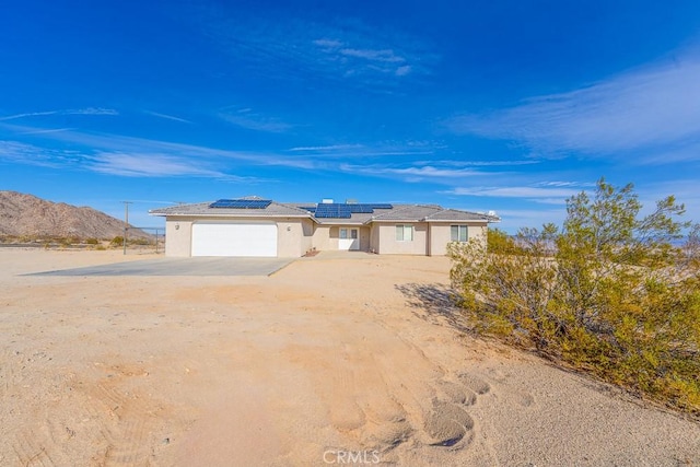 view of front of property featuring a mountain view, a garage, and solar panels