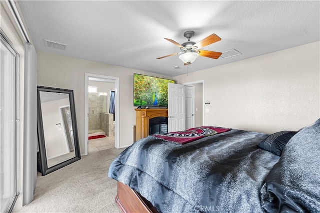 carpeted bedroom featuring ceiling fan and ensuite bath