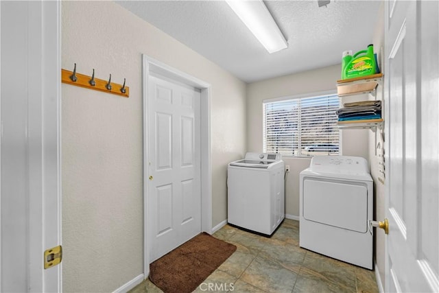 laundry area with washer and dryer and a textured ceiling