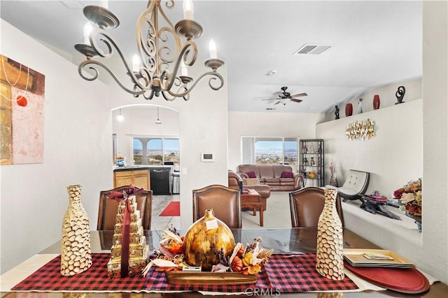 dining area featuring lofted ceiling and ceiling fan with notable chandelier