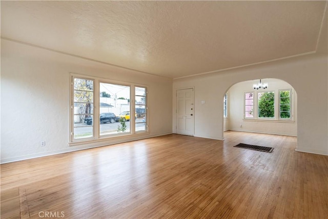 interior space featuring a textured ceiling, light hardwood / wood-style flooring, and a chandelier