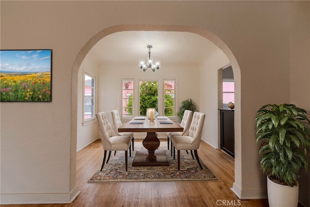 dining area with a notable chandelier and light hardwood / wood-style floors