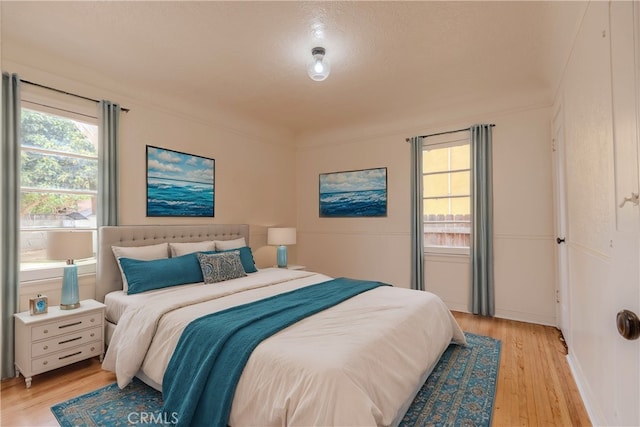 bedroom featuring ornamental molding and light wood-type flooring