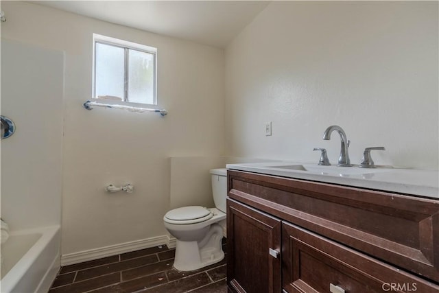 bathroom with vanity, a tub to relax in, and toilet