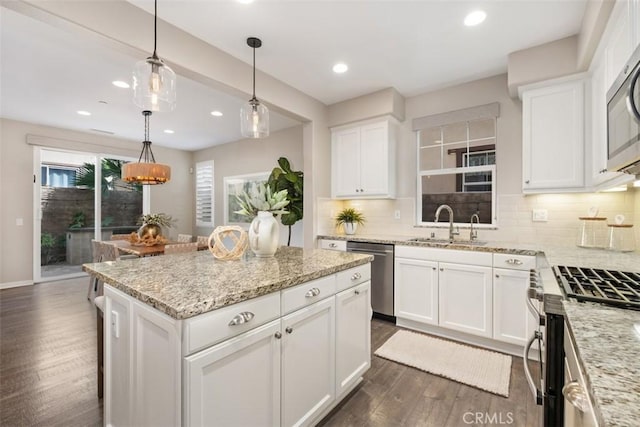 kitchen featuring hanging light fixtures, appliances with stainless steel finishes, dark wood-type flooring, and white cabinets