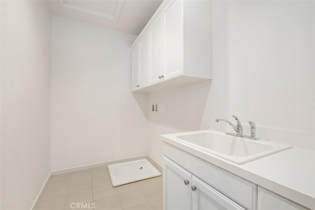 laundry room with cabinets, hookup for a washing machine, sink, and light tile patterned floors