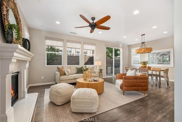 living room with dark wood-type flooring and ceiling fan