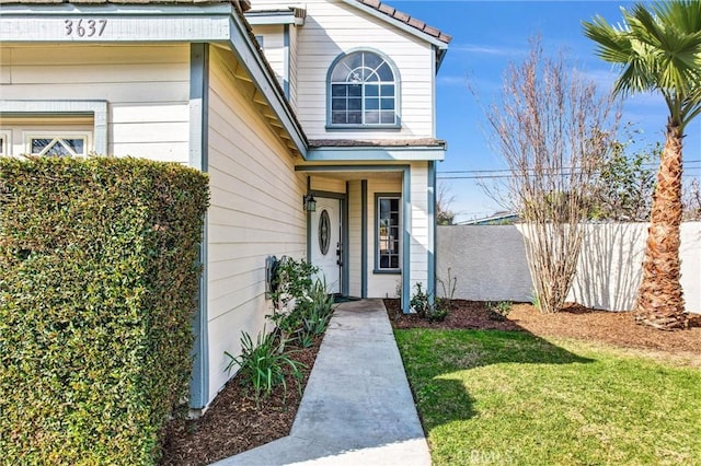 view of exterior entry featuring a yard