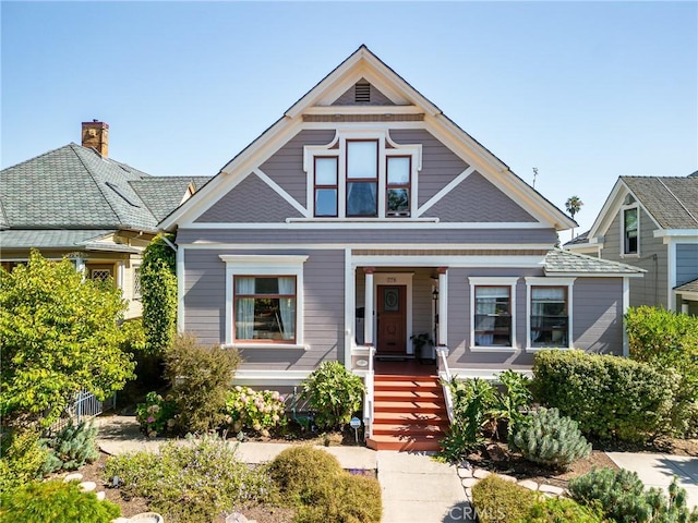 view of front of property with a porch and fence