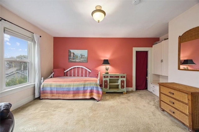 bedroom featuring light carpet and baseboards