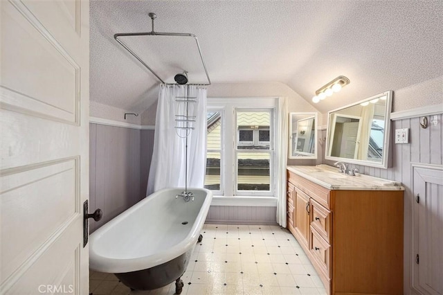 bathroom featuring vaulted ceiling, vanity, and a textured ceiling