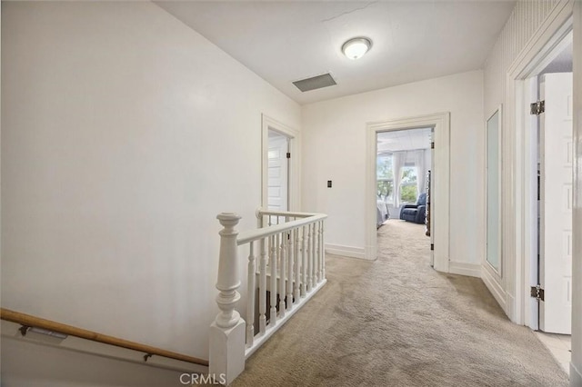 hall featuring light colored carpet