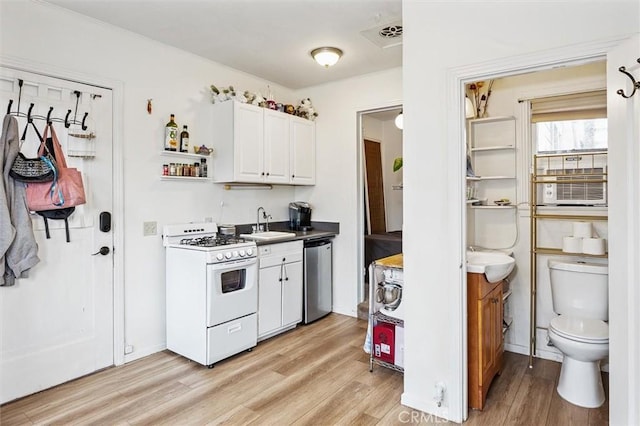 kitchen featuring white cabinetry, dishwasher, sink, light hardwood / wood-style floors, and gas range gas stove