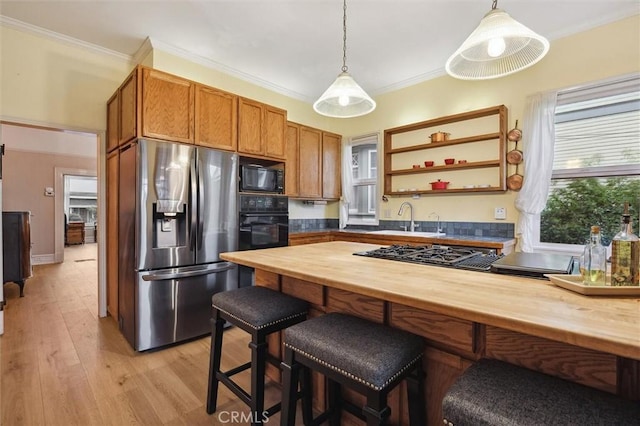 kitchen featuring wood counters, hanging light fixtures, and black appliances