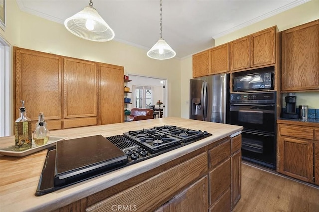 kitchen with pendant lighting, ornamental molding, and black appliances