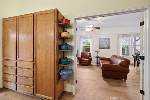 living room with a wealth of natural light, light hardwood / wood-style flooring, and ceiling fan