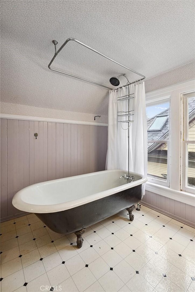 bathroom with a bathing tub and a textured ceiling