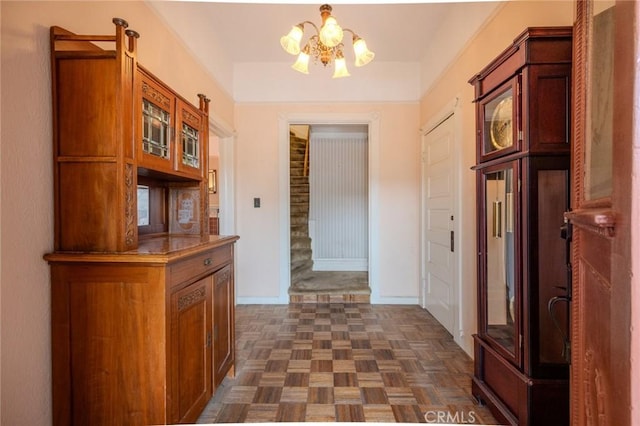 hall with an inviting chandelier and dark parquet flooring