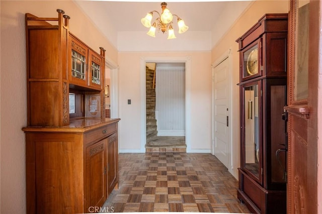 corridor with baseboards and an inviting chandelier