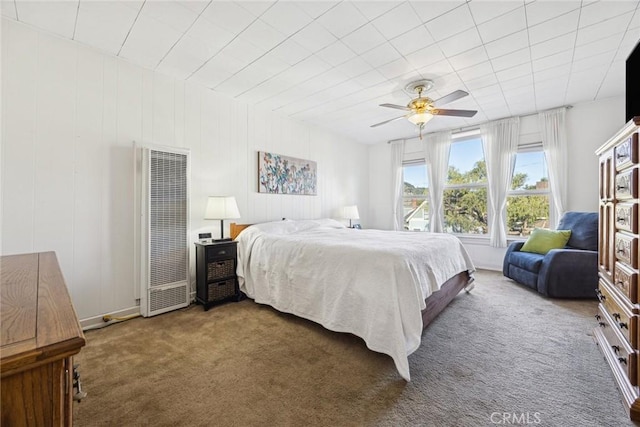 carpeted bedroom with a heating unit and a ceiling fan