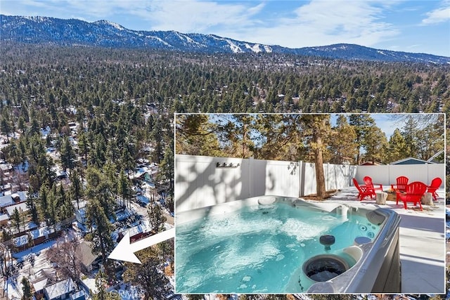 view of swimming pool featuring a hot tub and a mountain view