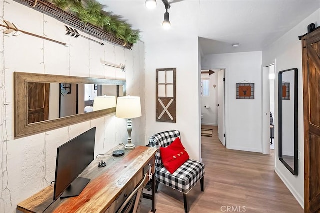 office area with a barn door and hardwood / wood-style floors