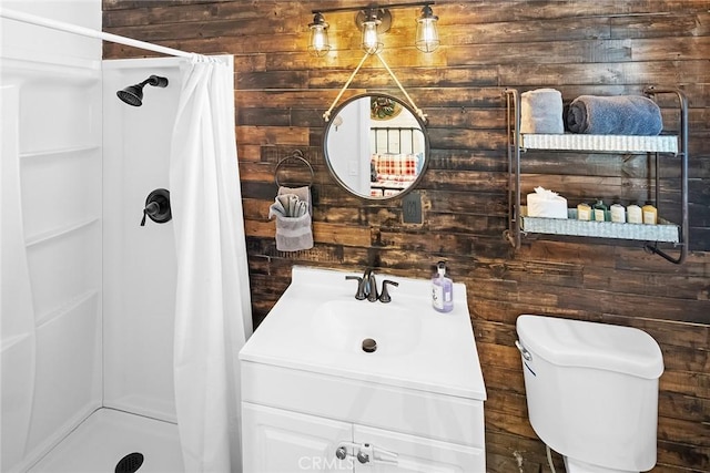 bathroom featuring wooden walls, vanity, toilet, and curtained shower