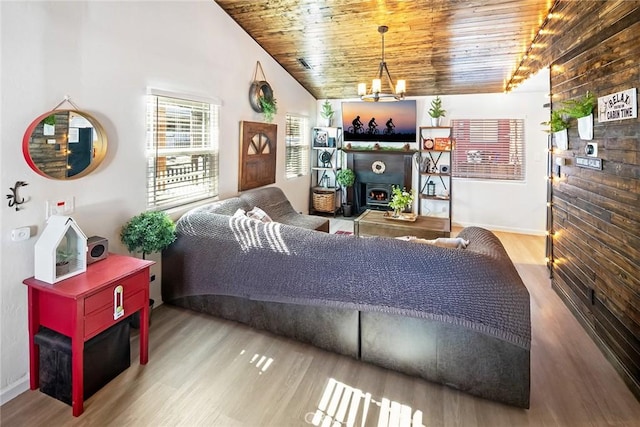 living room with a notable chandelier, hardwood / wood-style flooring, vaulted ceiling, and wooden ceiling