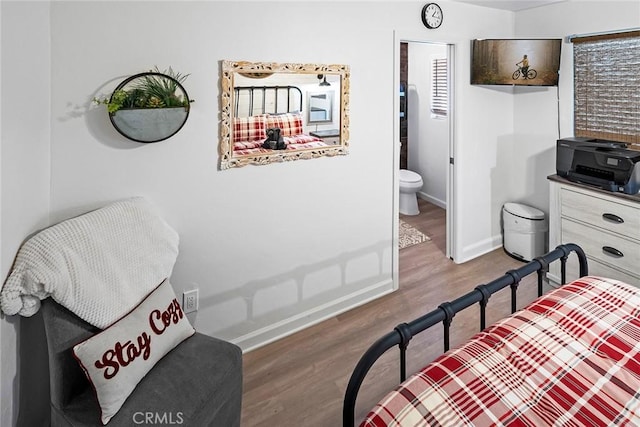 bedroom featuring connected bathroom and hardwood / wood-style floors