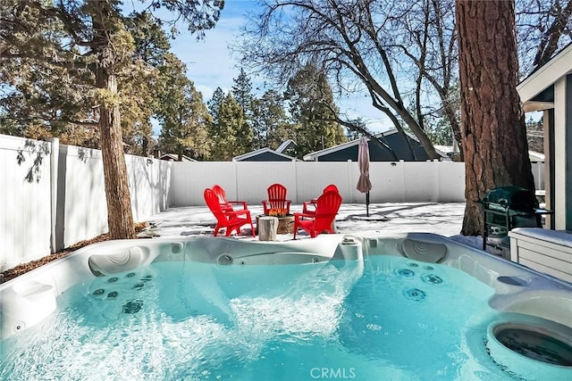 snow covered pool with a hot tub, a grill, and an outdoor fire pit