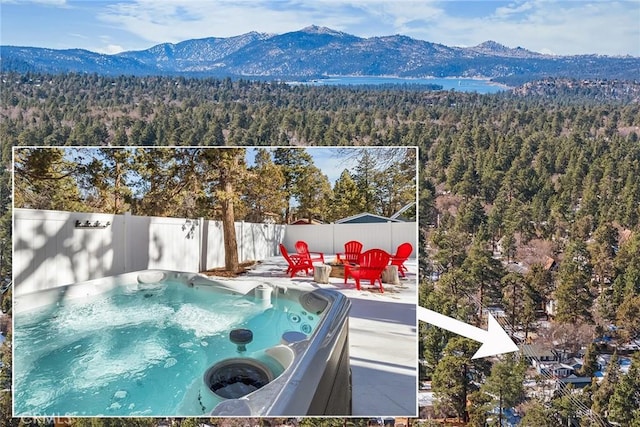 view of pool featuring a mountain view, a patio area, and a hot tub