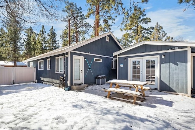 snow covered back of property with french doors