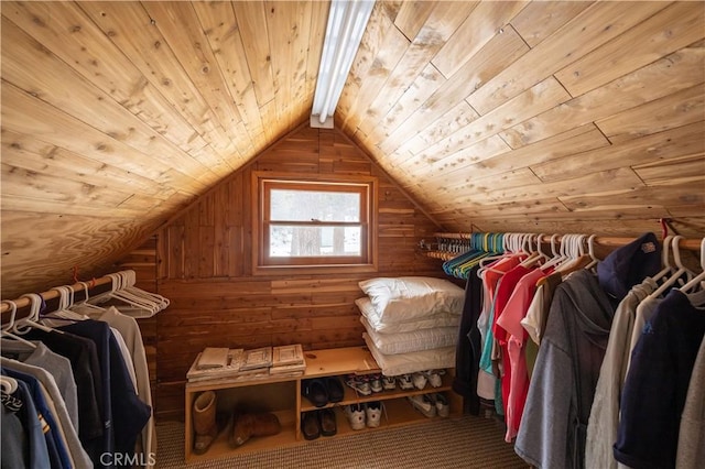 spacious closet featuring vaulted ceiling with beams and carpet floors