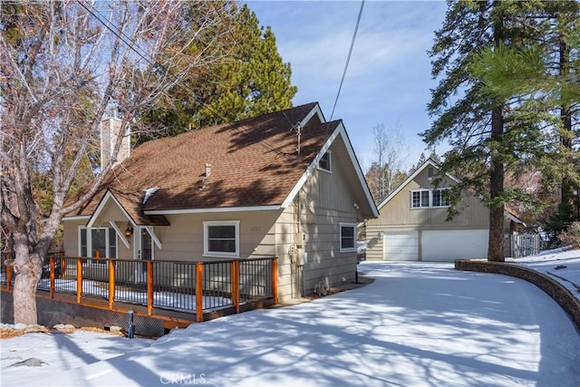 rear view of property with a garage and a wooden deck