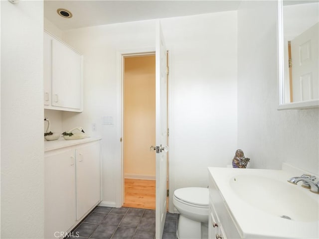 bathroom featuring vanity, tile patterned floors, and toilet