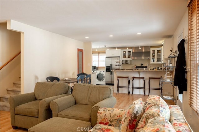 living room featuring washer / clothes dryer and light hardwood / wood-style flooring