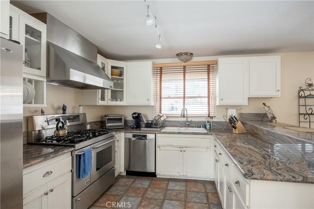 kitchen featuring appliances with stainless steel finishes, sink, white cabinets, and wall chimney exhaust hood