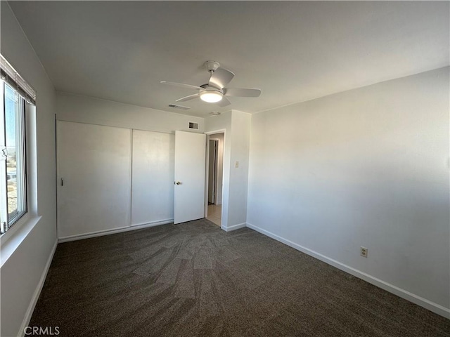 unfurnished bedroom featuring a closet, ceiling fan, and dark colored carpet