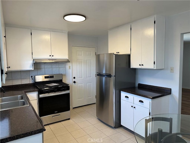 kitchen featuring sink, light tile patterned floors, stainless steel appliances, decorative backsplash, and white cabinets