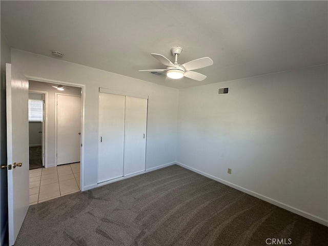 unfurnished bedroom with light carpet, ceiling fan, and a closet