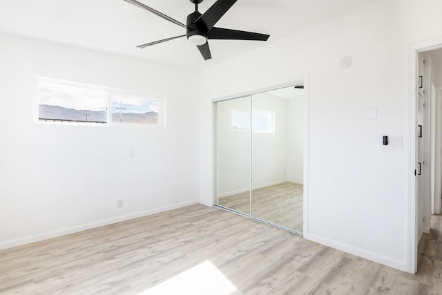 unfurnished bedroom featuring ceiling fan, light wood-type flooring, and a closet