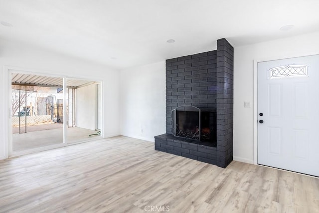 unfurnished living room with a fireplace and light hardwood / wood-style flooring