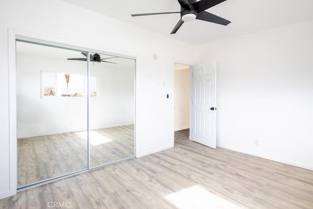 unfurnished bedroom featuring ceiling fan, light wood-type flooring, and a closet